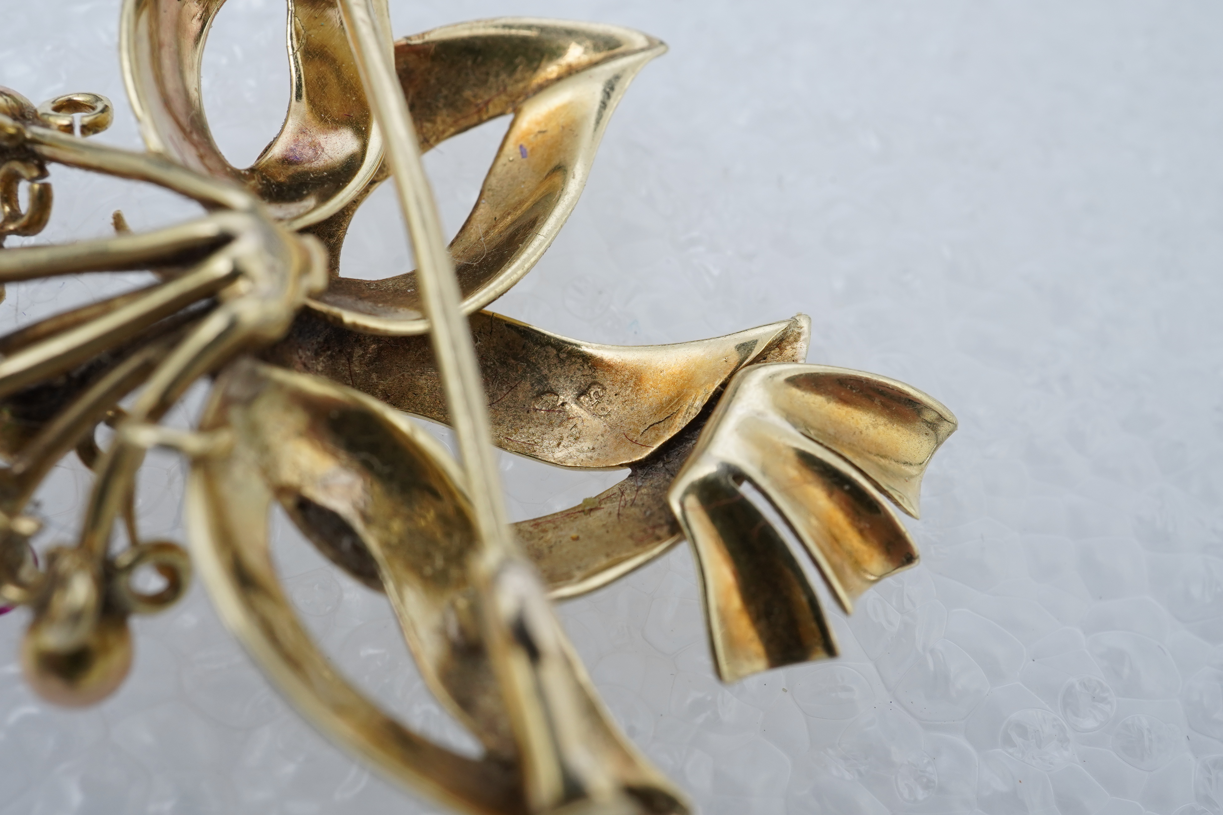 Two brooches and a ring, mid 20th century, comprising: a brooch of floral design, set with circular-cut synthetic gemstones, length 3.7cm, Austrian assay marks for gold, gross weight approximately 6.5 grams; a brooch des